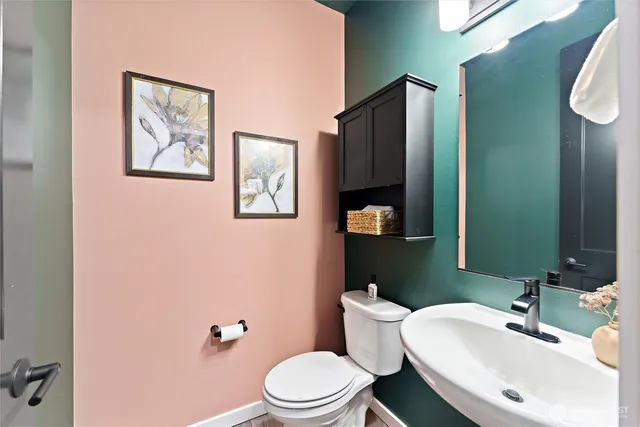 a bathroom with a toilet sink and mirror
