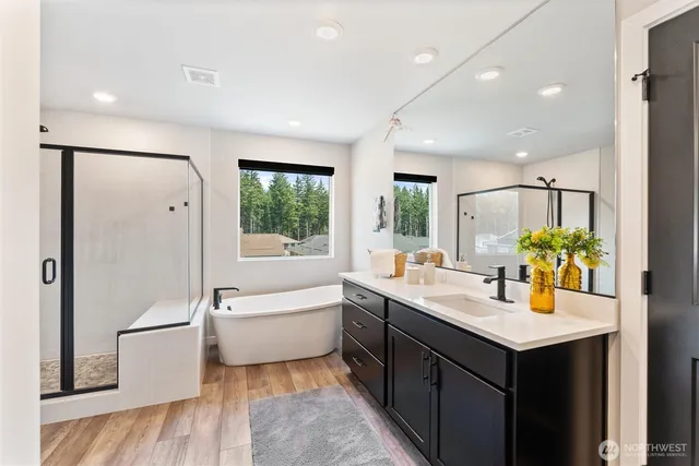 a bathroom with a tub sink and mirror