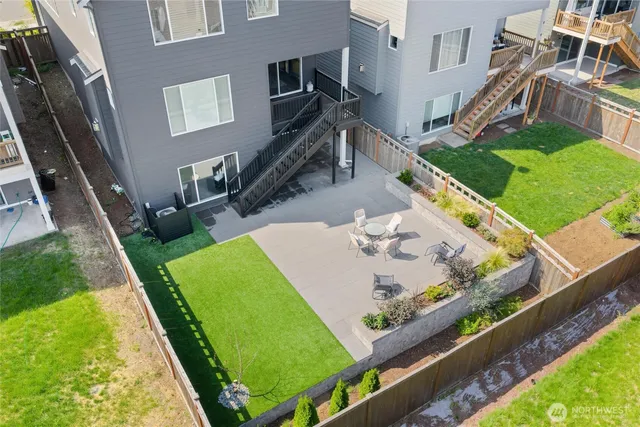 a view of a patio with table and chairs under an umbrella with wooden fence