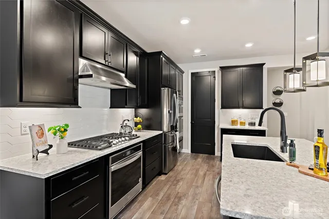 a kitchen with stainless steel appliances granite countertop a sink stove and refrigerator
