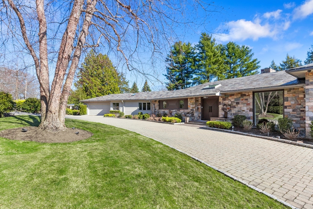 a front view of a house with yard and green space