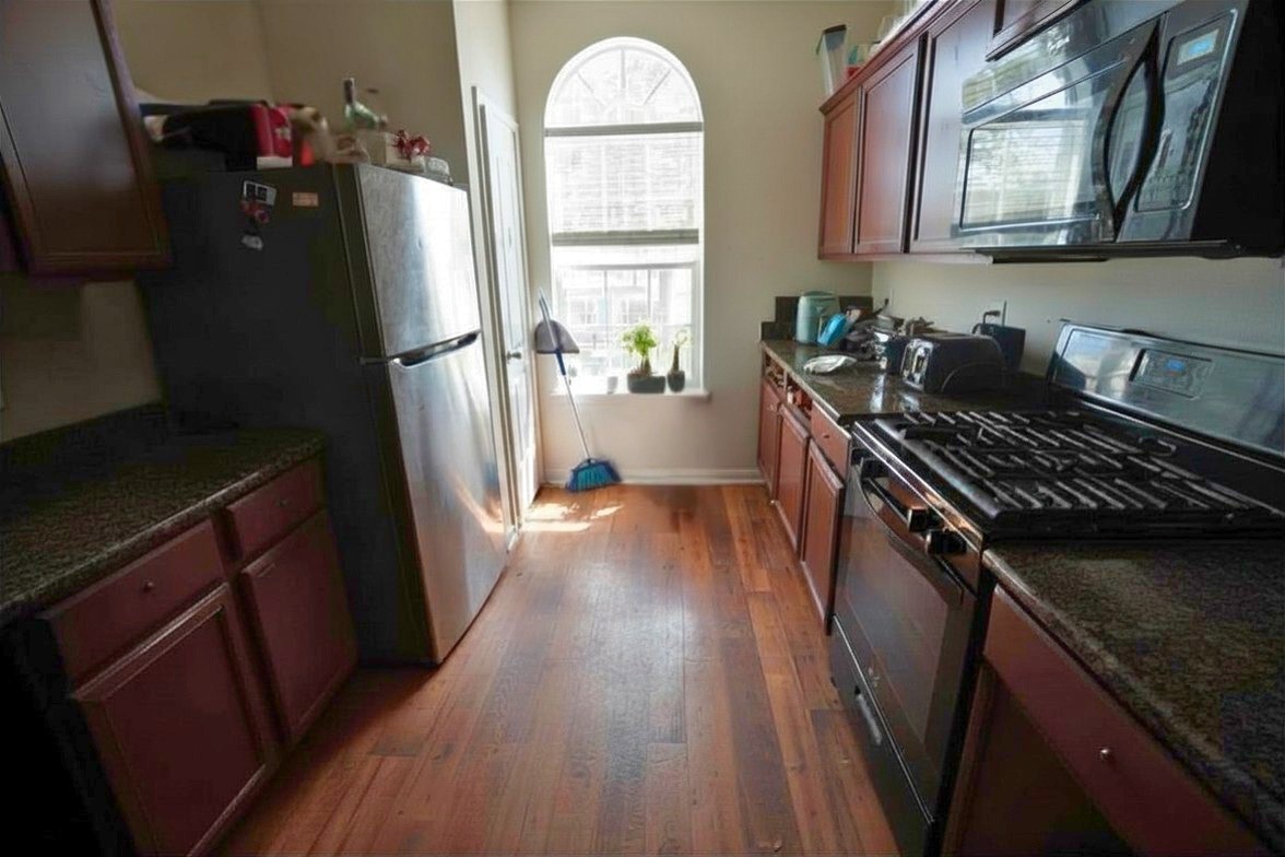 1835 Garnet Breeze Drive Rosharon, TX 77583 - Photo 4 of 19 a kitchen with granite countertop a refrigerator a stove top oven and a window