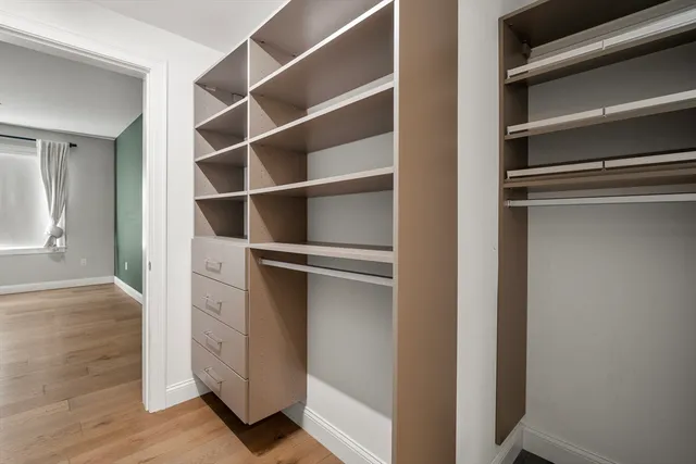 a view of walk in closet with empty racks