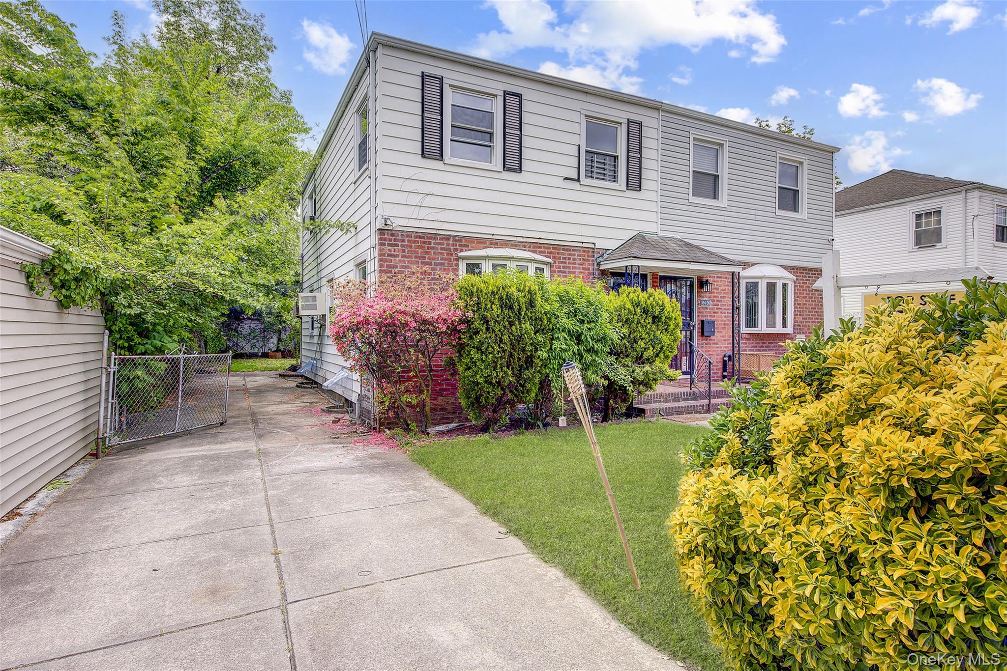 164-38 76th Road Queens, NY 11366 - Photo 41 of 44 a front view of a house with a yard and potted plants