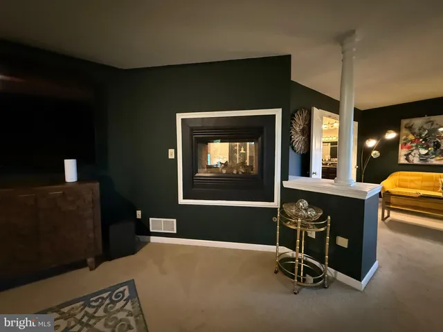a living room with fireplace furniture and a large window