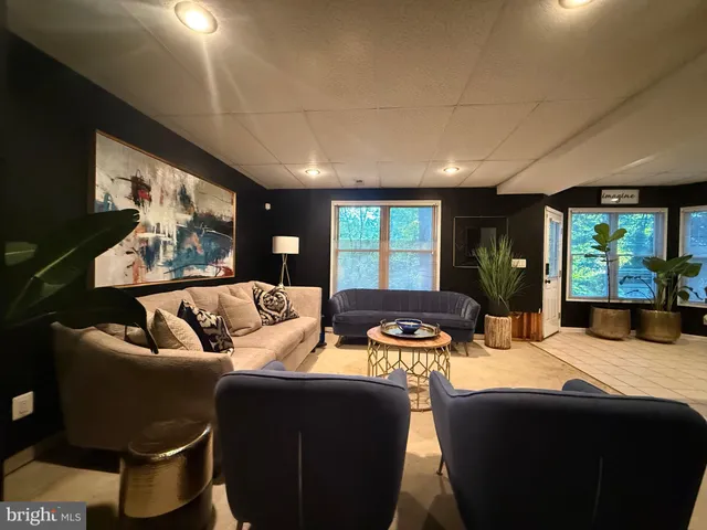 a open kitchen with stainless steel appliances kitchen island granite countertop a sink a stove a dining table and chairs with wooden floor