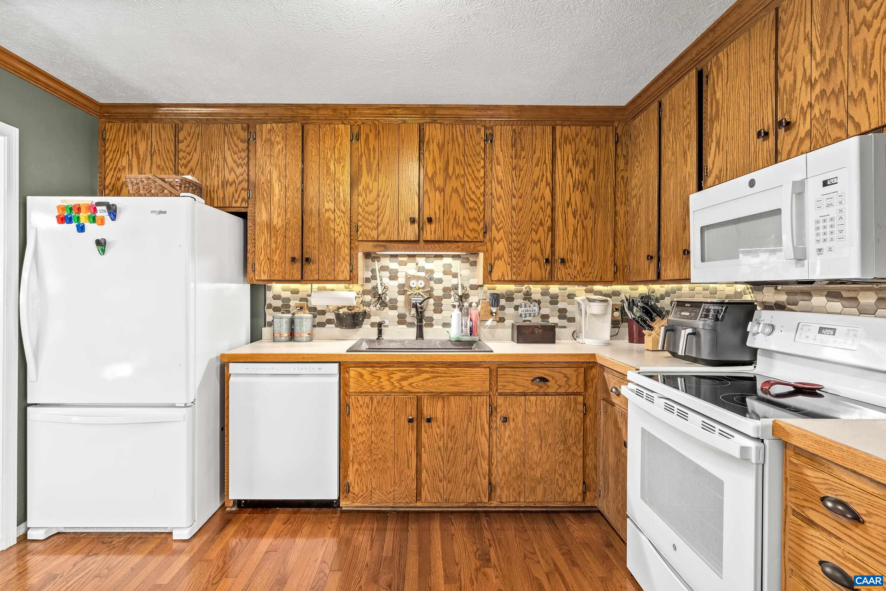 89 Fox Hollow Road Ruckersville, VA 22968 - Photo 13 of 37 a white refrigerator freezer sitting inside of a kitchen with stainless steel appliances granite countertop wooden cabinets a refrigerator and a sink