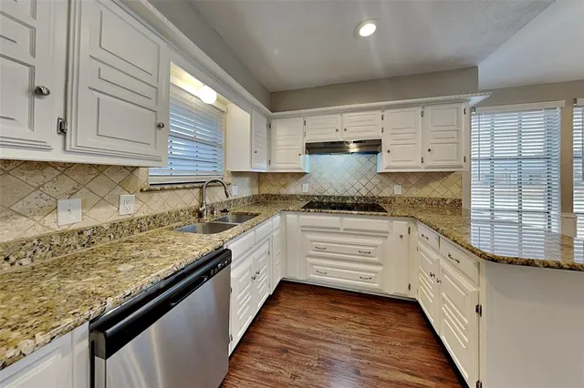 a kitchen with granite countertop white cabinets and white appliances