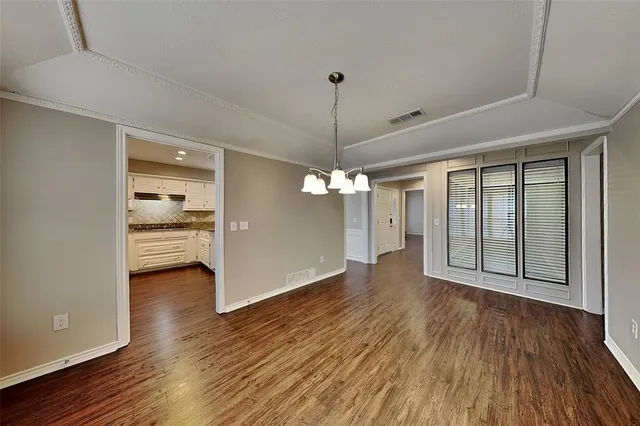 a view of a room with wooden floor a ceiling fan and a window