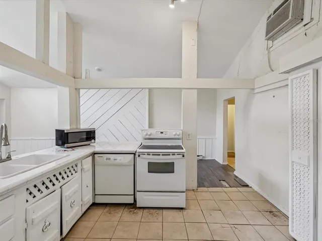 a kitchen with a stove sink and cabinets