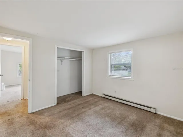 an empty room with windows and closet