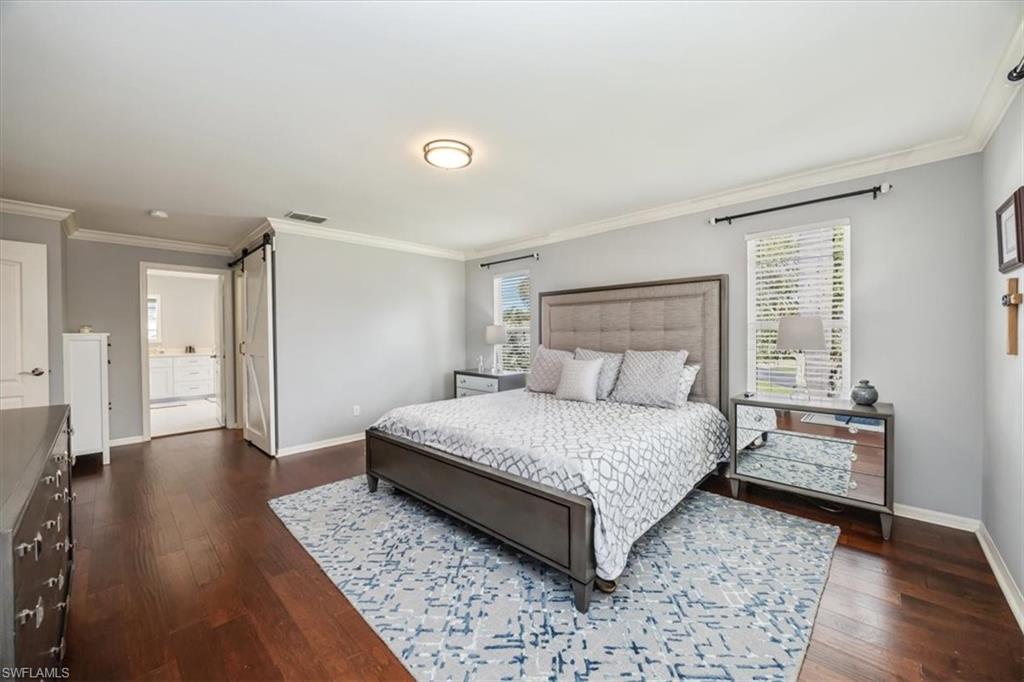 2066 Imperial Circle Naples, FL 34110 - Photo 14 of 29 a spacious bedroom with a bed and wooden floor