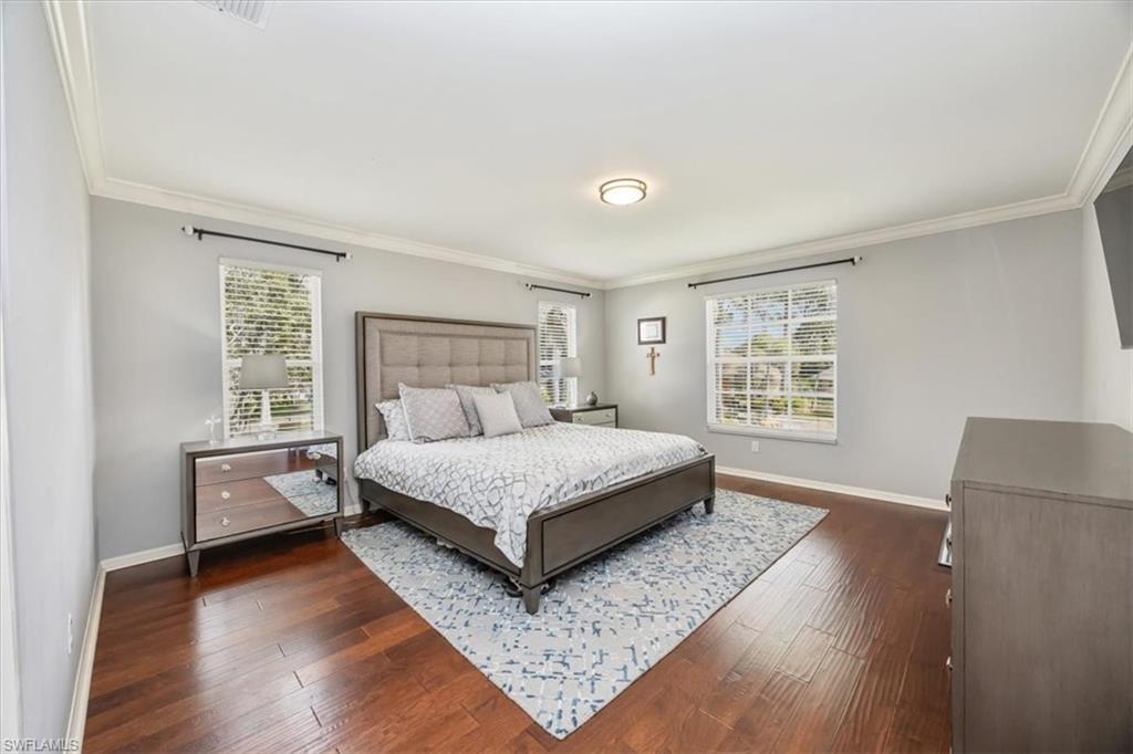 2066 Imperial Circle Naples, FL 34110 - Photo 15 of 29 a bedroom with a bed and window with wooden floor