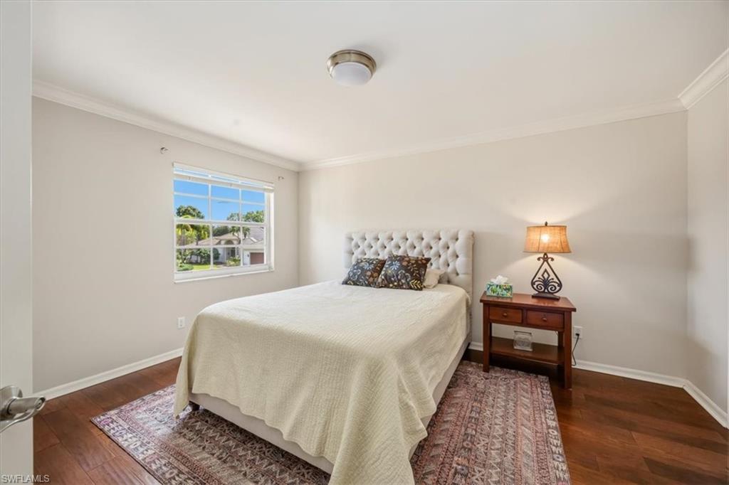2066 Imperial Circle Naples, FL 34110 - Photo 22 of 29 a bedroom with a bed and wooden floor
