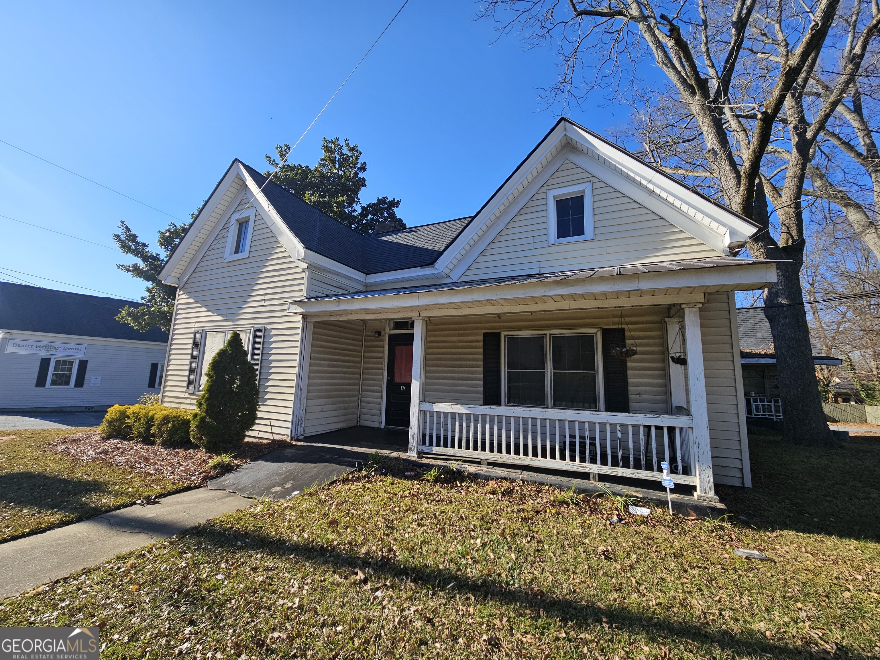 a view of a house with a yard and large tree