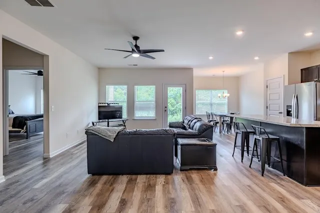 a living room with furniture a large window and a chandelier