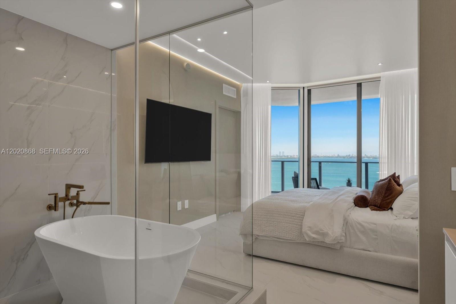 700 Northeast 24th Street, Unit 1602 Miami, FL 33137 - Photo 29 of 30 a bedroom with a bed and a flat screen tv