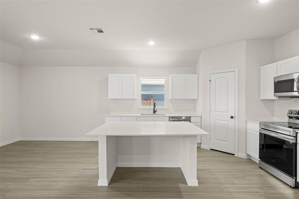 426 Rose Avenue Cleburne, TX 76033 - Photo 15 of 20 a kitchen with a sink cabinets and wooden floor