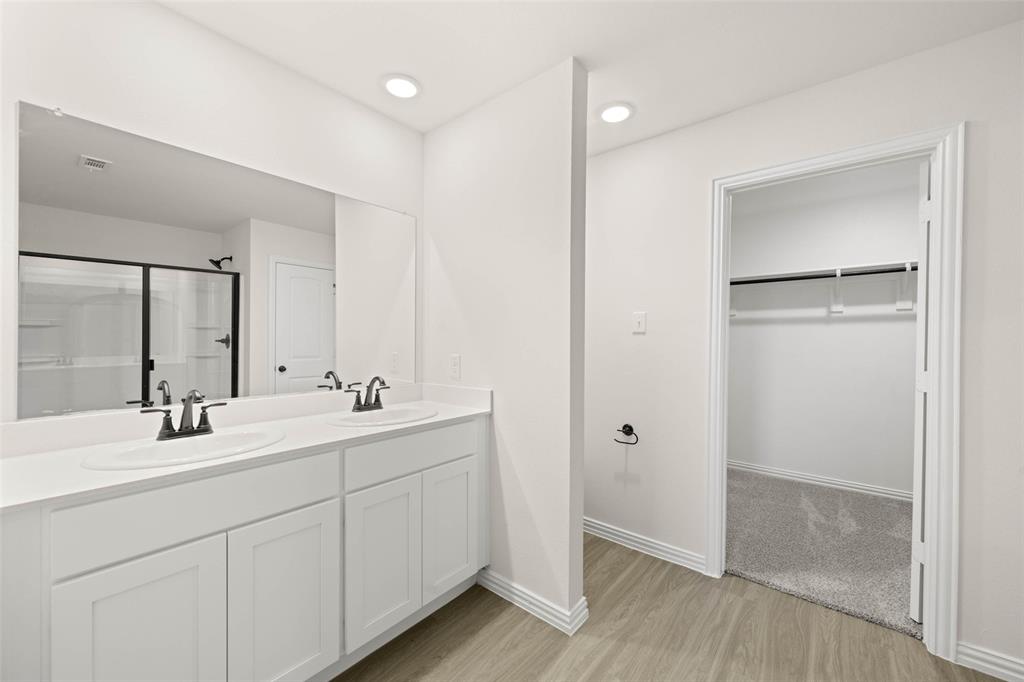 426 Rose Avenue Cleburne, TX 76033 - Photo 18 of 20 a bathroom with a double vanity sink a mirror and a shower