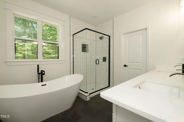 a bathroom with a white tub shower and sink