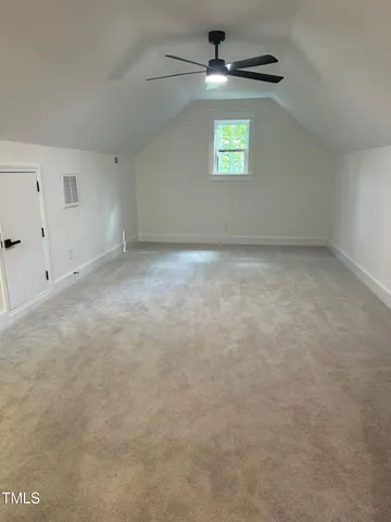an empty room with windows and ceiling fan