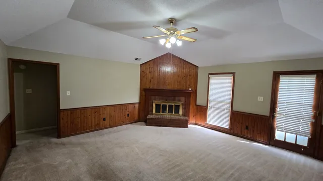 a view of a livingroom with a fireplace cabinet and window