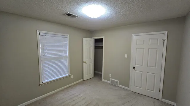 an empty room with windows and closet