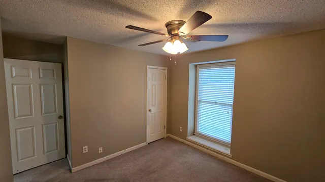 a view of a livingroom with a ceiling fan and window