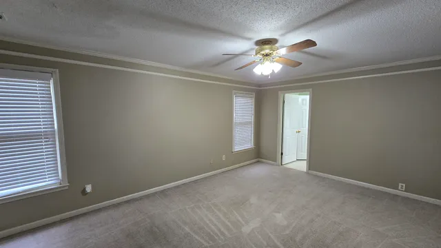 an empty room with closet and a chandelier fan