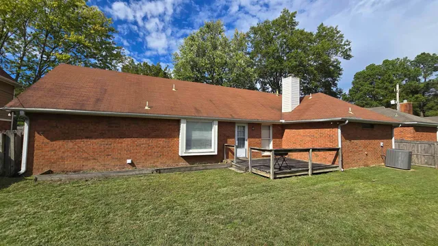 an aerial view of a house with garden space and a bench
