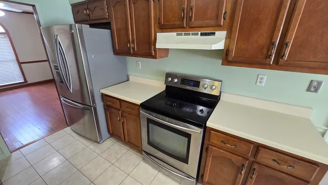 a kitchen with stainless steel appliances wooden cabinets sink and a stove