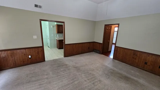 an empty room with window and hardwood