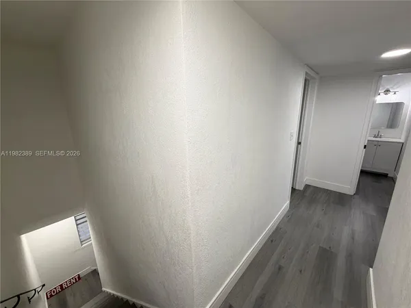 a view of a hallway with wooden floor