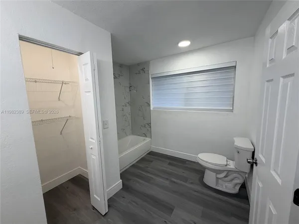 a bathroom with double vanity sink a two mirror a window and a bathtub