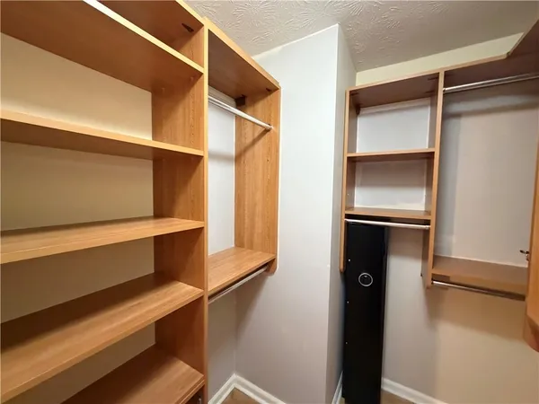 a view of walk in closet with empty racks
