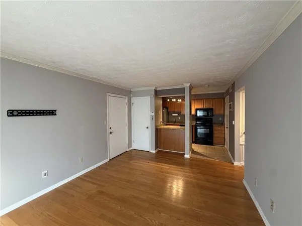 a view of empty room with wooden floor