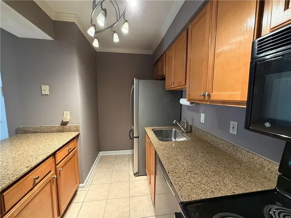 a kitchen with granite countertop a sink a stove and a refrigerator