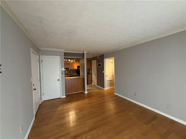 a view of an empty room and window and wooden floor