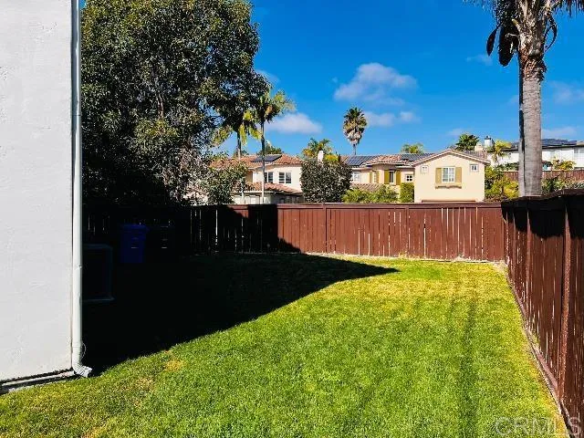 a living room with stainless steel appliances kitchen island granite countertop a refrigerator a stove and a cabinets with wooden floor