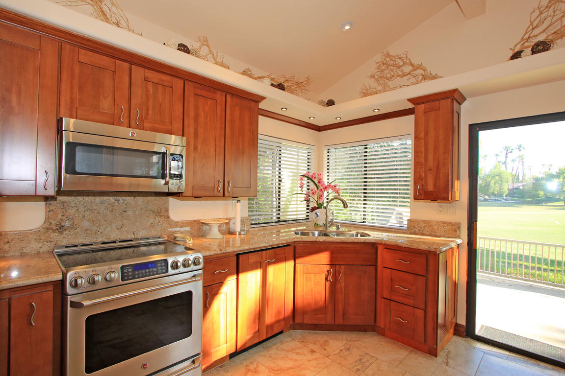 210 Wagon Wheel Road Palm Desert, CA 92211 - Photo 11 of 27 a kitchen with granite countertop a sink stainless steel appliances wooden cabinets and a counter top space