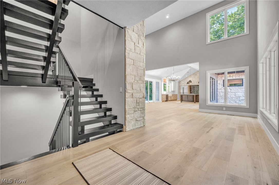 4009 Brainard Road Beachwood, OH 44122 - Photo 12 of 50 Stairs with a notable chandelier, light wood-type flooring, and a towering ceiling