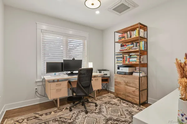 a view of a workspace with furniture and a window