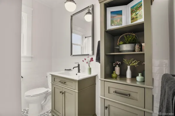 a bathroom with a toilet sink and mirror