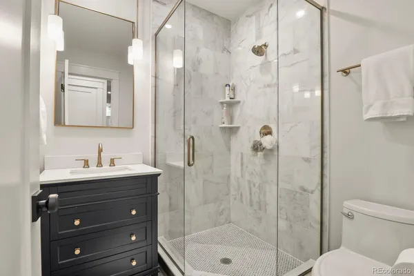 a bathroom with a sink a toilet and shower