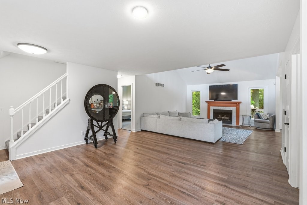2323 Call Road Stow, OH 44224 - Photo 7 of 42 Spacious living area featuring wood-finish flooring, a fireplace with a wood mantle and stone surround, vaulted ceilings, and a ceiling fan