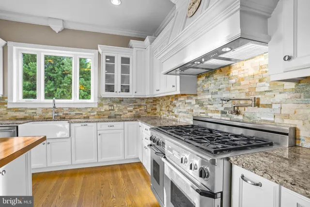 a kitchen with a stove a sink and a window