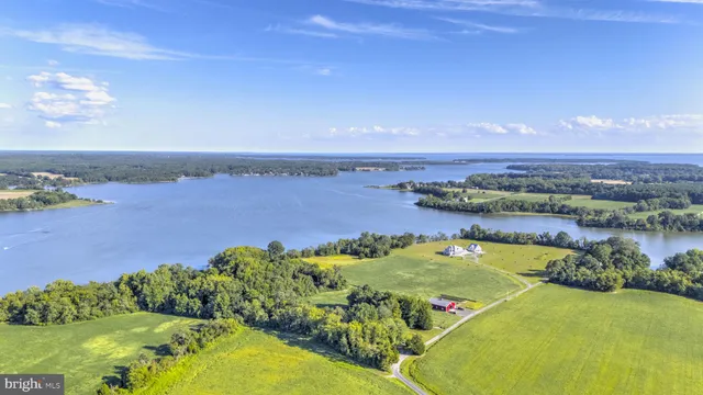 an aerial view of ocean and residential houses with outdoor space