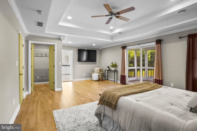 a spacious bedroom with a large bed and a wooden floor