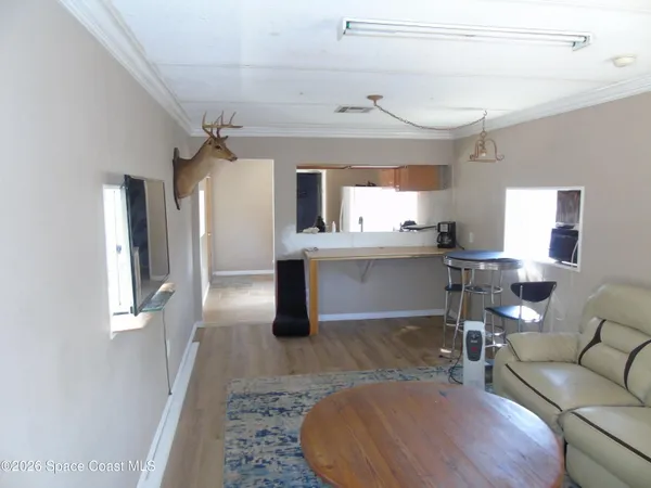 a living room with a couch and a view of kitchen