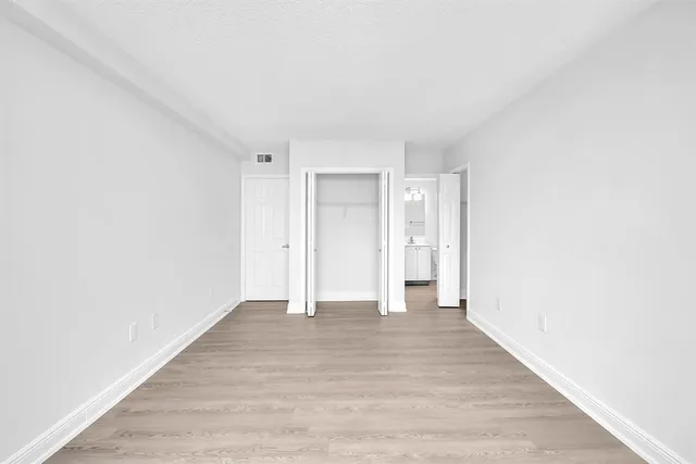a view of an empty room with wooden floor